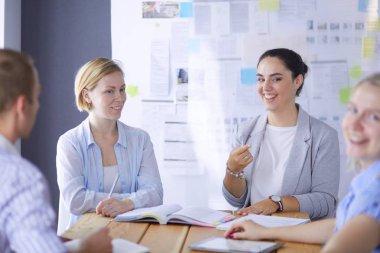 Masada kitaplarla çalışan gençler. Güzel kadınlar ve erkekler birlikte çalışıyor..