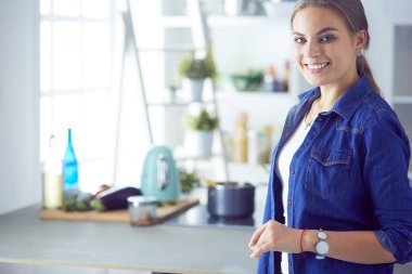 Mutfakta yemek hazırlayan genç bir kadın.