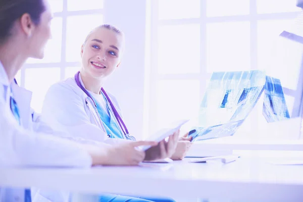 Female doctors looking and discussing x-ray image at hospital. — Stock Photo, Image