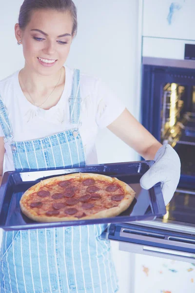 Happy young woman cooking pizza at home — Stock Photo, Image