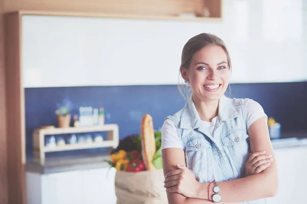 Portrait de jeune femme debout avec les bras croisés sur fond de cuisine — Photo