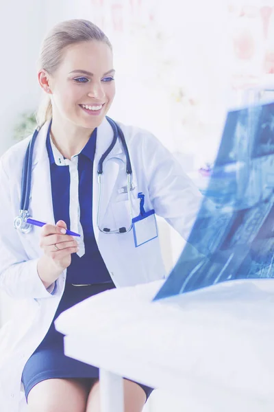Jovem atraente médico feminino olhando para a imagem de raio-x — Fotografia de Stock