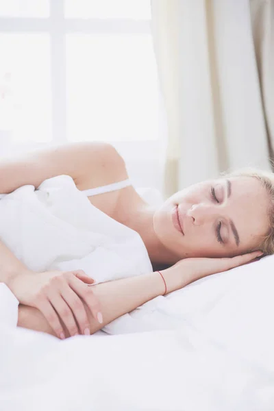 Pretty woman lying down on her bed at home — Stock Photo, Image