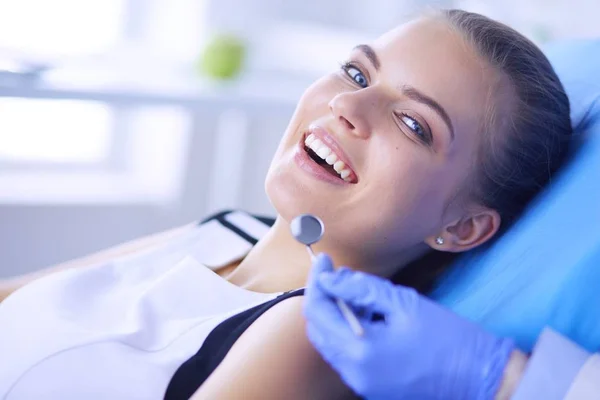 Mujer joven con la boca abierta examinando la inspección dental en el consultorio del dentista. — Foto de Stock