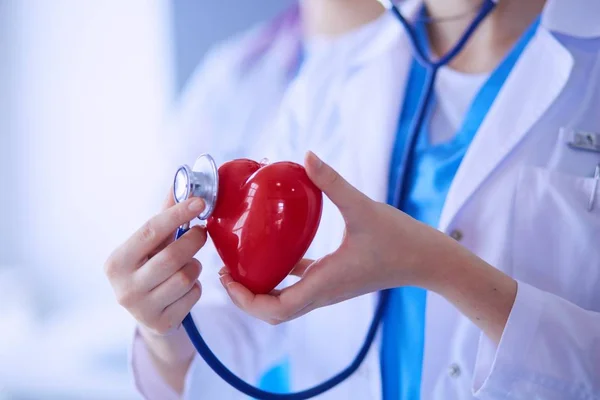 Tiro cortado de dois jovens médicos do sexo feminino com estetoscópio segurando coração. — Fotografia de Stock