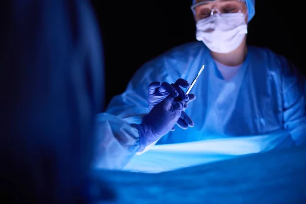 Geschnittenes Bild von Skalpell entnommenen Ärzten, die chirurgische Eingriffe durchführen. — Stockfoto