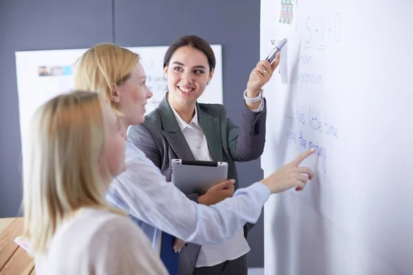 Business, education and office concept - business team with flip board in office discussing something. — Stock Photo, Image