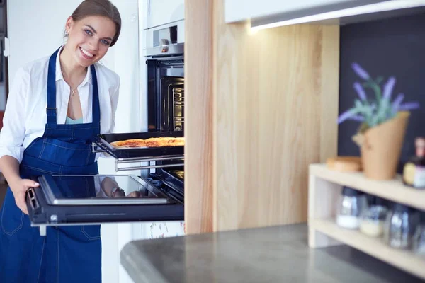 Feliz joven cocinando pizza en casa — Foto de Stock