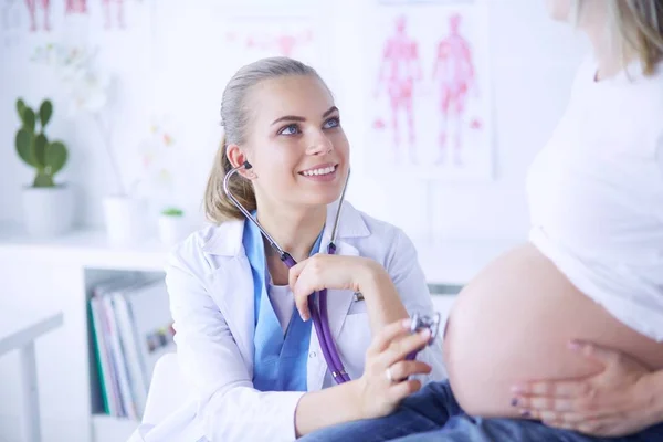 Usmívající se žena lékař ukazuje obrázky na tabletu těhotné mladé ženě v nemocnici. — Stock fotografie