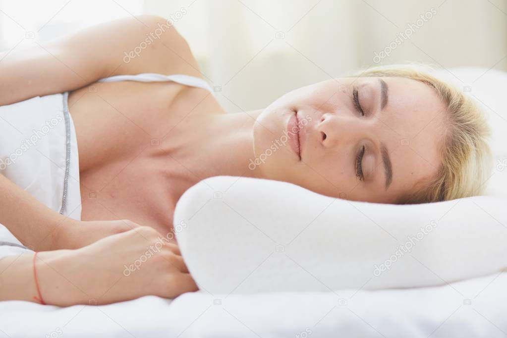 Pretty woman lying down on her bed at home