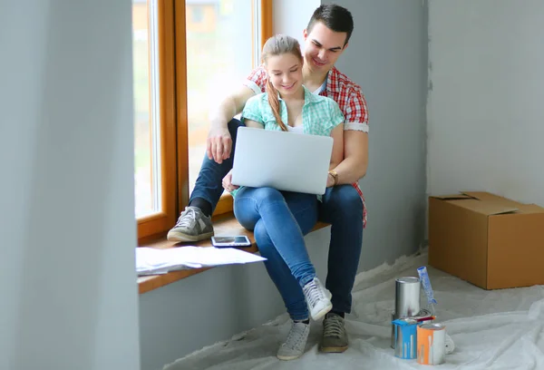 Para, przenoszenie, siedząc w domu na parapecie z laptopa — Zdjęcie stockowe