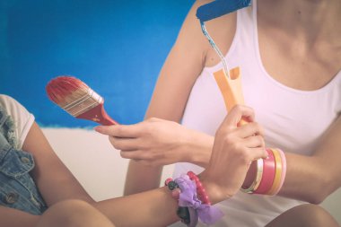 Duvar resmi yapıyor, oturan iki güzel genç kadın. İki güzel genç kadın.