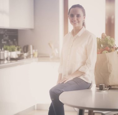 Giderleri planlama ve mutfağını faturalarında ödeme genç kadın.