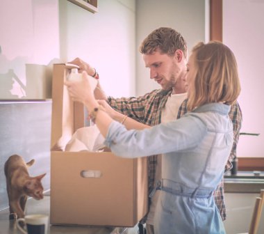 Genç bir çift yeni evde büyük karton kutu taşıyan. Ev taşıma. Genç Çift