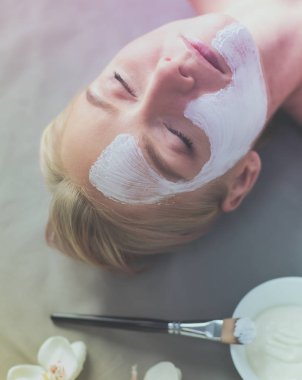 Yüz maskesi. Güzel genç kız Spa, makyajcısı kadın yüz maskesi uygulama.