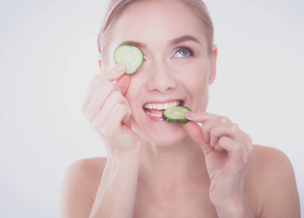 Young beautiful woman with cucumber slices on white background. — Stock Photo, Image