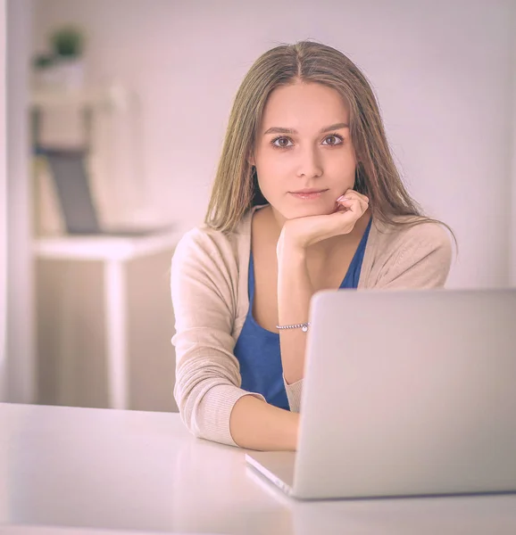 Schöne junge Frau mit Laptop am Schreibtisch — Stockfoto