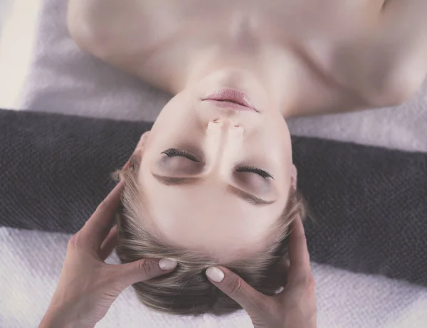 Jovem deitada em uma mesa de massagem, relaxando com os olhos fechados. Mulher. Salão de Spa — Fotografia de Stock