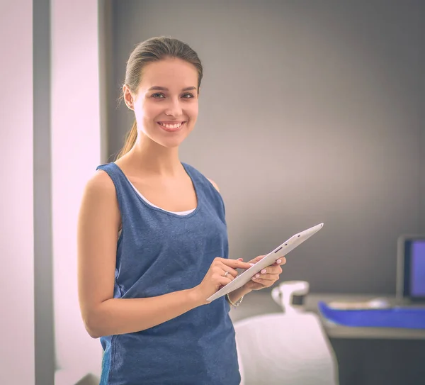 Aantrekkelijke vrouw die op een tablet werkt in een thuiskantoor — Stockfoto