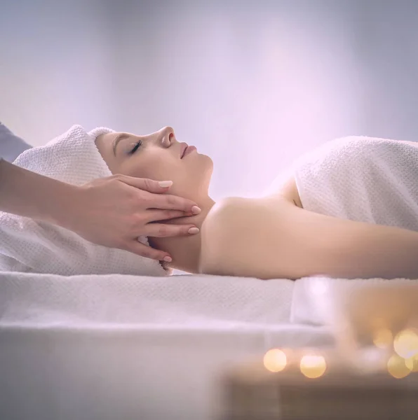 Jovem deitada em uma mesa de massagem, relaxando com os olhos fechados. Mulher. Salão de Spa — Fotografia de Stock