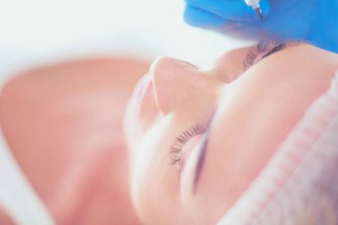 Kaşlar için kalıcı makyaj. Güzellik salonunda kalın kaşlı güzel bir kadın..