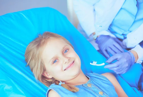 Niña sentada en el consultorio de dentistas. —  Fotos de Stock