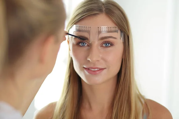 Permanente make-up voor wenkbrauwen. Close-up van mooie vrouw met dikke wenkbrauwen in schoonheidssalon. — Stockfoto