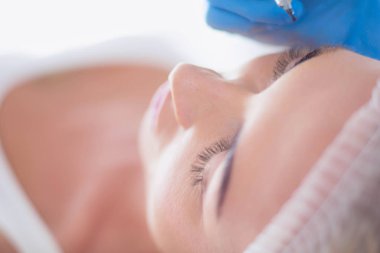 Kaşlar için kalıcı makyaj. Güzellik salonunda kalın kaşlı güzel bir kadın..