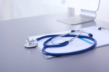 Tıbbi ekipman: Beyaz arka planda mavi steteskop ve tablet. Tıbbi ekipman