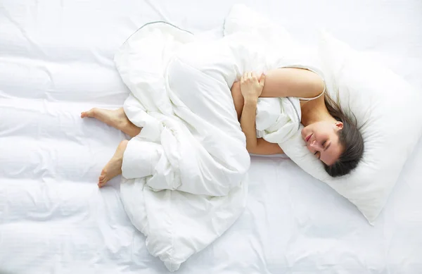 Junge Frau empfindet Schmerzen im Bett. — Stockfoto