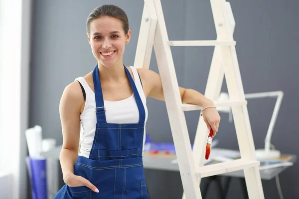 Donna operaia con trapano in piedi in nuova casa . — Foto Stock