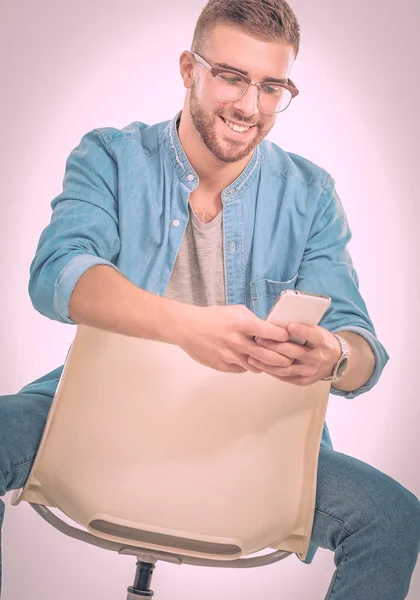 Joven sentado en la silla y usando el teléfono móvil. Startupper. Joven empresario . — Foto de Stock