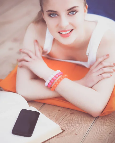 Jeune femme souriante couchée sur un sol blanc avec oreiller — Photo