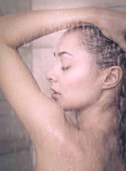 Ung, vakker kvinne under dusjen på badet. . – stockfoto