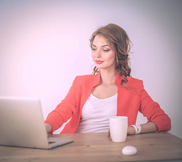 Attraktive Frau sitzt im Büro am Schreibtisch und arbeitet mit Laptop — Stockfoto