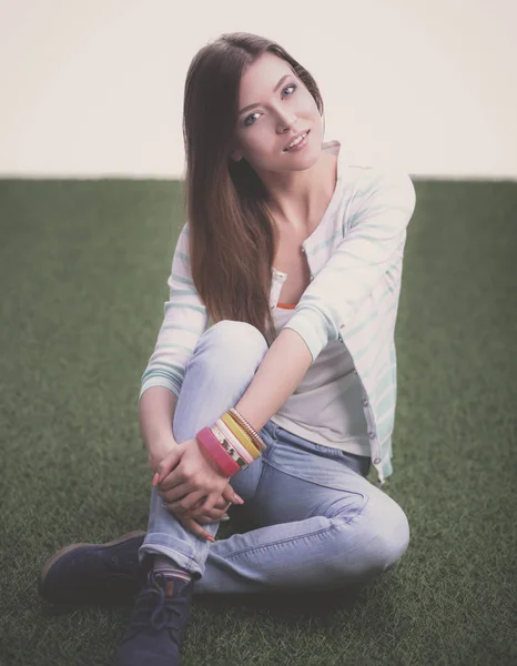 Vacker ung kvinna som sitter i gräset — Stockfoto