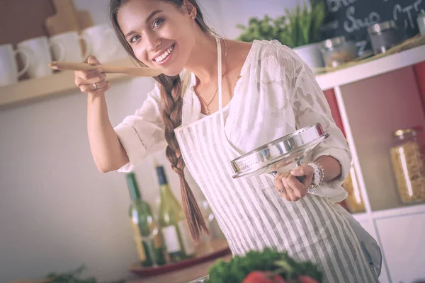 Mujer cocinera en cocina con cuchara de madera — Foto de Stock