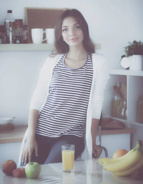 Fiatal nő ül az íróasztal mellett a konyhában — Stock Fotó