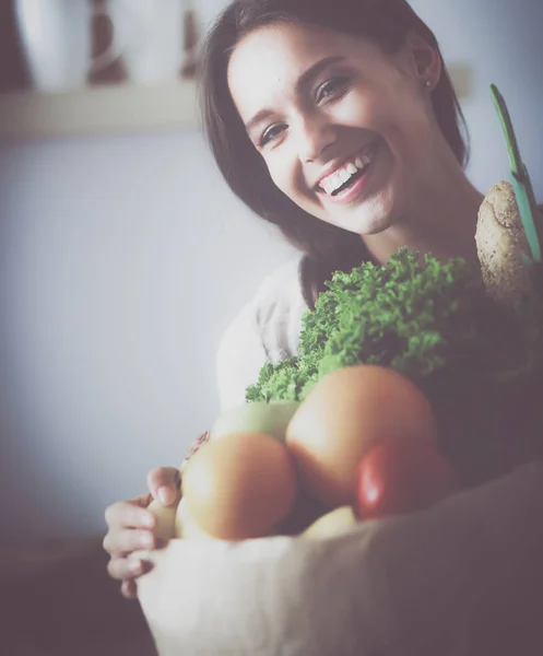 Young woman holding grocery shopping bag with vegetables — Stock Photo, Image