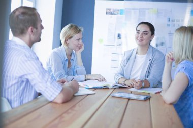 Masada kitaplarla çalışan gençler. Güzel kadınlar ve erkekler birlikte çalışıyor..