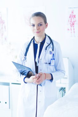 Üniformalı bir dosyayla gülümseyen kadın doktor