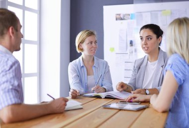 Masada kitaplarla çalışan gençler. Güzel kadınlar ve erkekler birlikte çalışıyor..