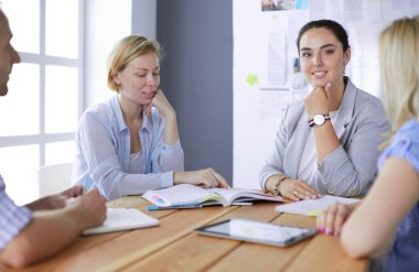 Masada kitaplarla çalışan gençler. Güzel kadınlar ve erkekler birlikte çalışıyor..