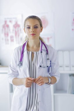 Üniformalı tıbbi bir steteskopla gülümseyen kadın doktor.