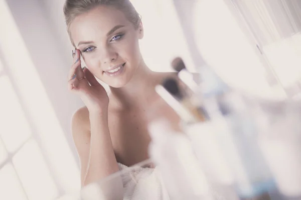Jovem mulher em roupão olhando no espelho do banheiro — Fotografia de Stock