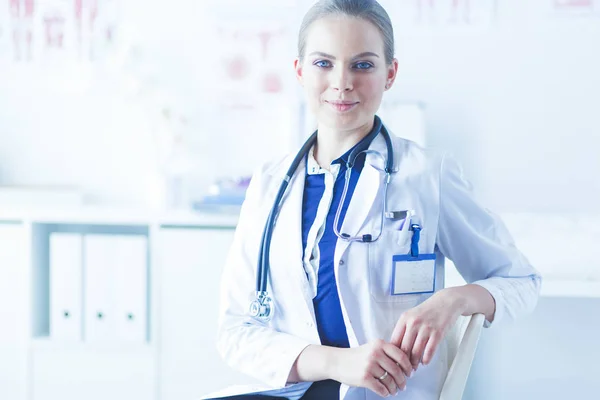 Retrato de uma jovem médica sentada à mesa no hospital — Fotografia de Stock