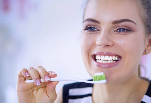 年轻漂亮的女孩用牙刷保持口腔卫生. — 图库照片