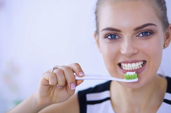 Joven chica bonita manteniendo la higiene bucal con cepillo de dientes . — Foto de Stock