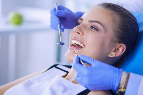 Mujer joven con la boca abierta examinando la inspección dental en el consultorio del dentista. — Foto de Stock