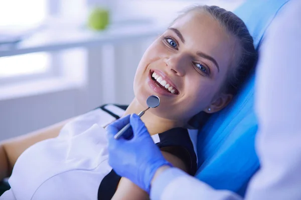 在牙科诊所检查牙齿的年轻女性病人，面带笑容. — 图库照片